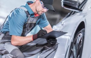 car mechanic checking items off car maintenance list