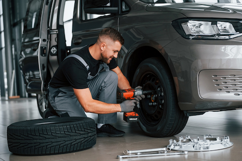 auto mechanic working on a car tire