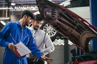 car mechanic discusses auto repair services with a customer