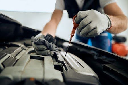 Austin auto mechanic checking a car’s oil levels