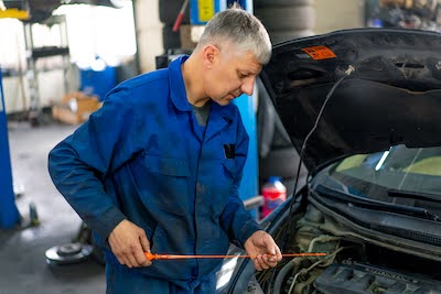 Austin auto mechanic checking oil levels during an oil change service