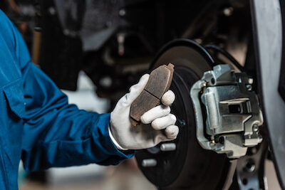 auto mechanic holding a brake pad